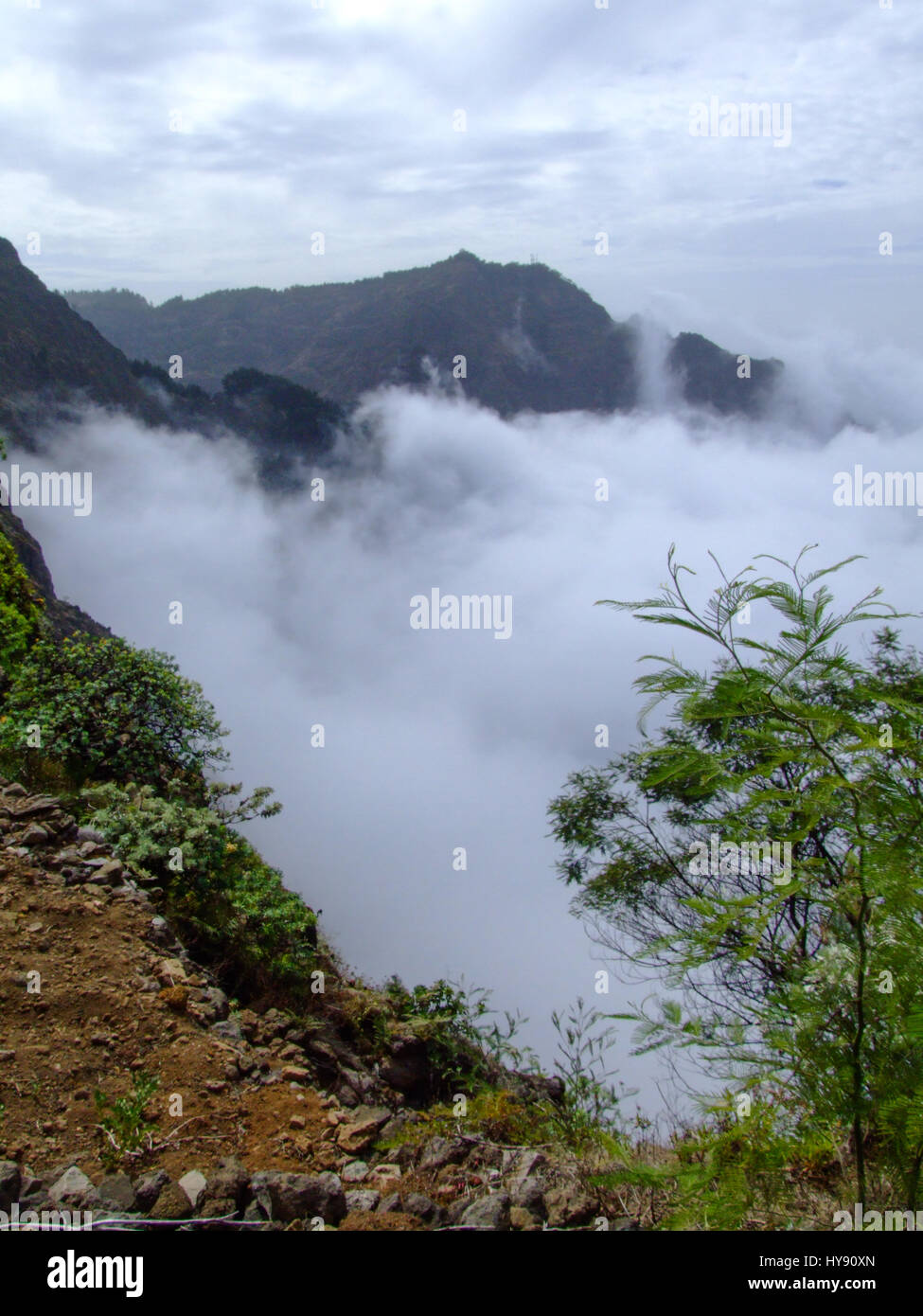 Nuvole basse oscura la vista delle valli e dei canyon sotto la cresta cime di montagna di Santo Antao, Repubblica di Cabo Verde sulla Rua de corda Foto Stock