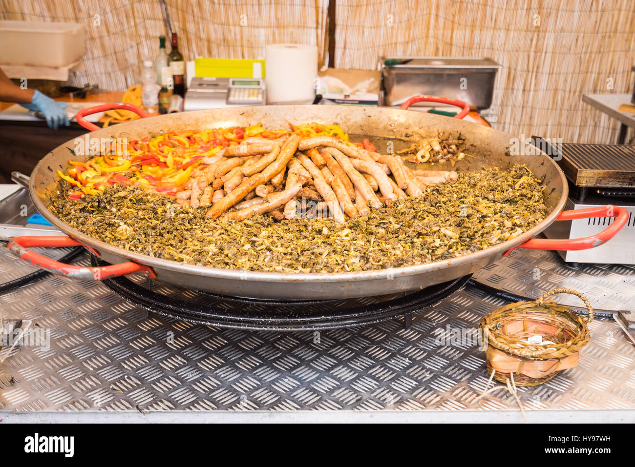 Cibi tipici della Puglia con salsiccia, rape top e peperoni, preparato in una pentola di grandi dimensioni durante una fiera alimentare Foto Stock