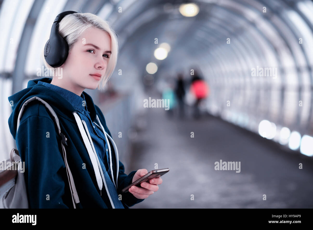 Giovane studente ascoltando musica in grandi cuffie in metropolitana Foto  stock - Alamy