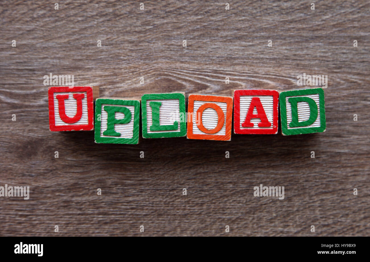 Il blocco di legno lettere che compongono la parola caricare Foto Stock