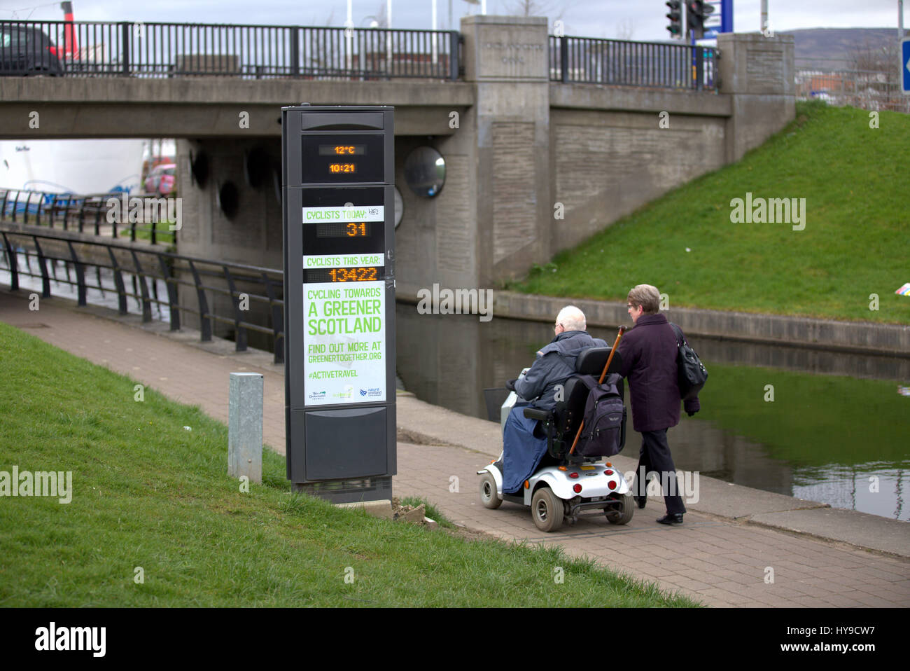 Greener scozia #activetravel passando pedoni caregiver e mobilità scooter sulla via Clyde canale percorso ciclabile clydebank Foto Stock