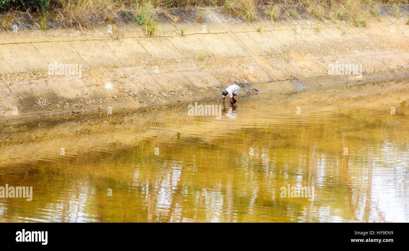 Pescatore tribali per la cattura di pesce in acqua del canale con lo spazio di copia Foto Stock