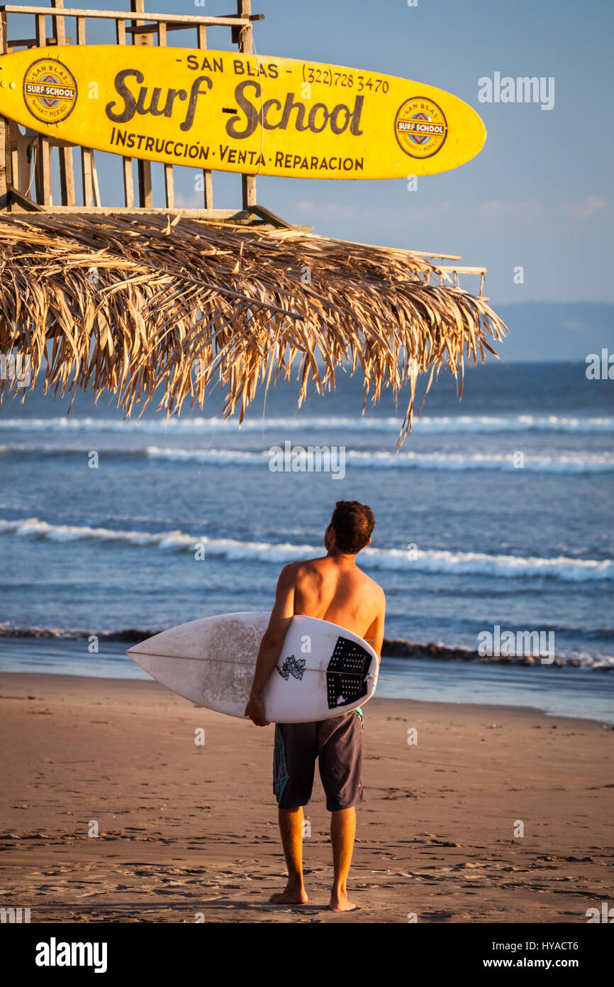 Un surfista arriva a San Blas scuola di surf sulla spiaggia di San Blas, Nayarit, Messico. Foto Stock