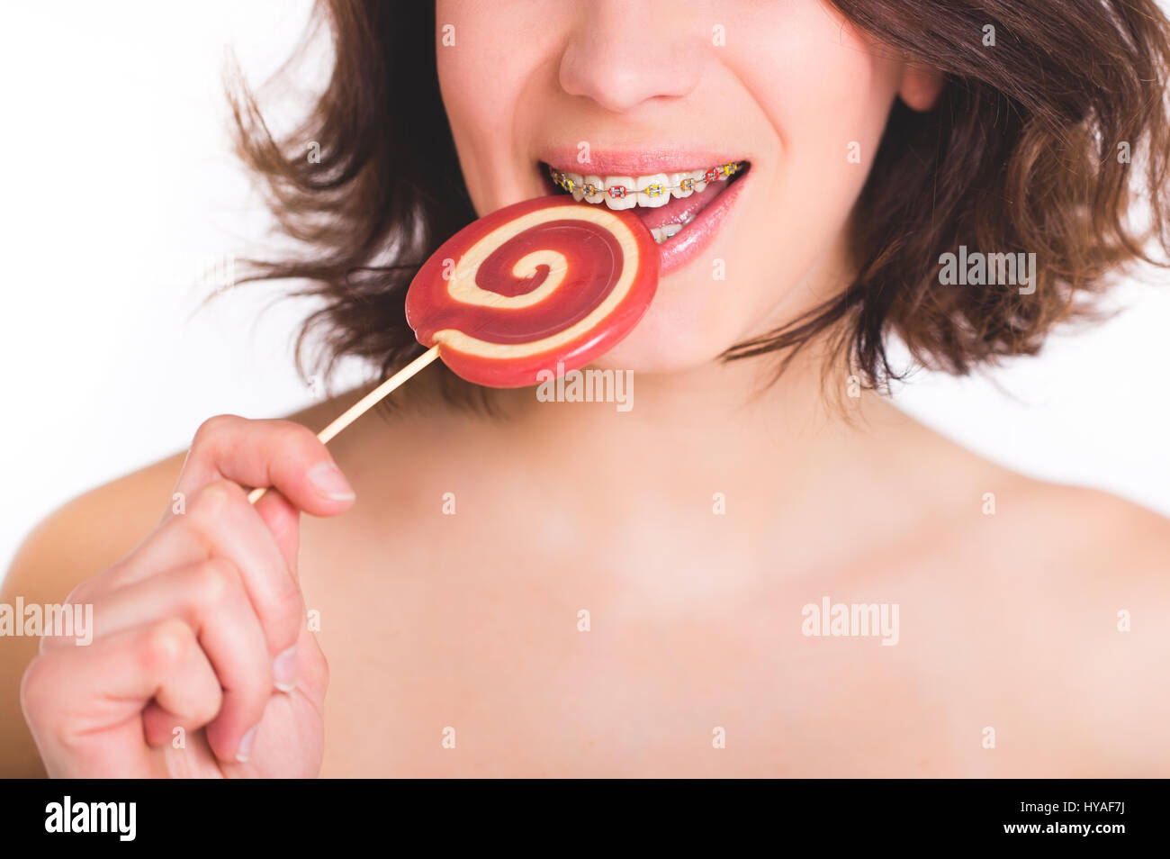Giovane donna con multi-colore di staffaggio e caramelle. Concetto dentale Foto Stock