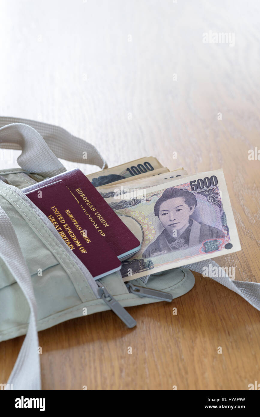 Tracolla custodia denaro cintura, con pagamento in contanti e passaporti.valuta giapponese ,Yen, steso su un tavolo. Foto Stock