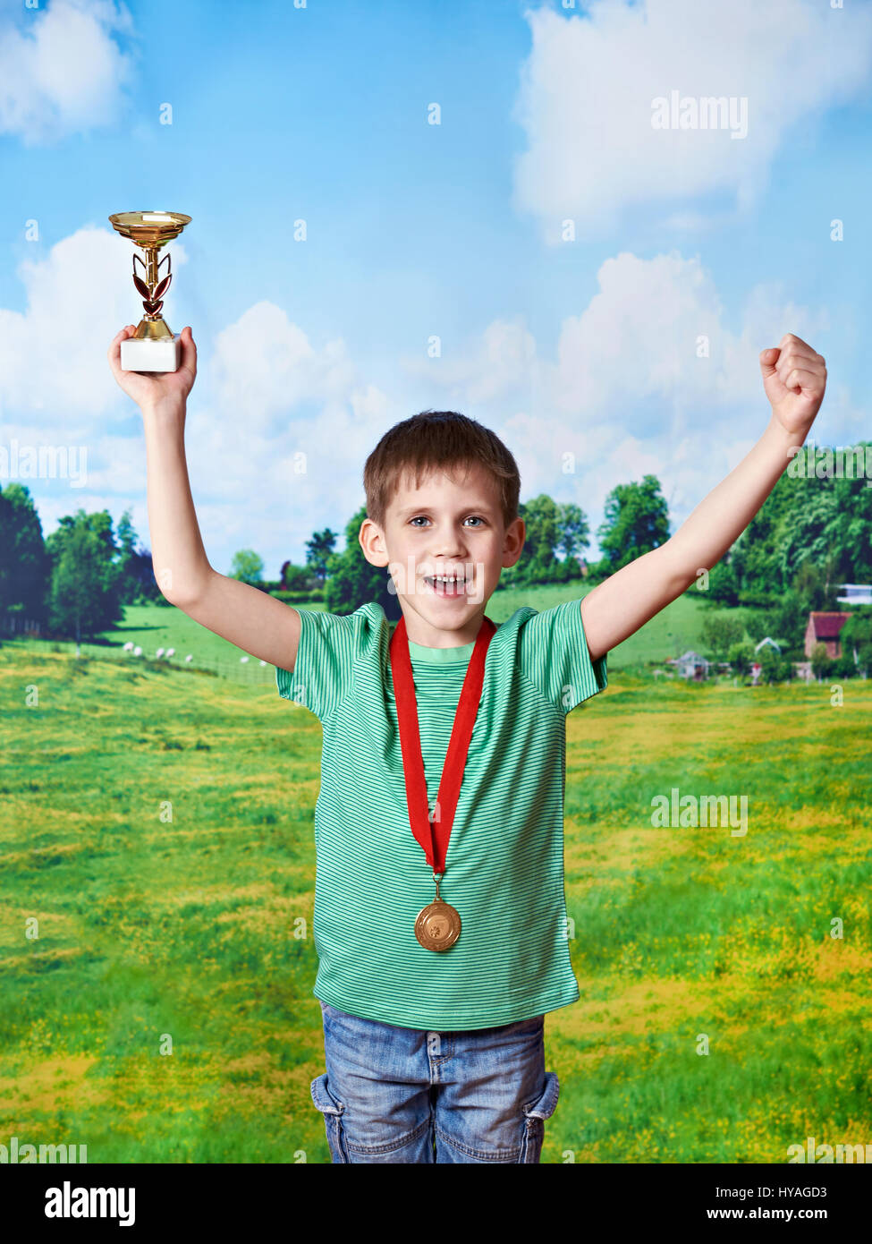 Ragazzo sportivo vincitore con la coppa e medaglia su sfondo natura Foto Stock