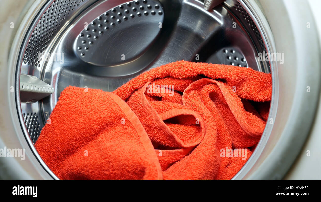 Lavaggio e asciugatura macchina con asciugamano rosso in servizio lavanderia Foto Stock