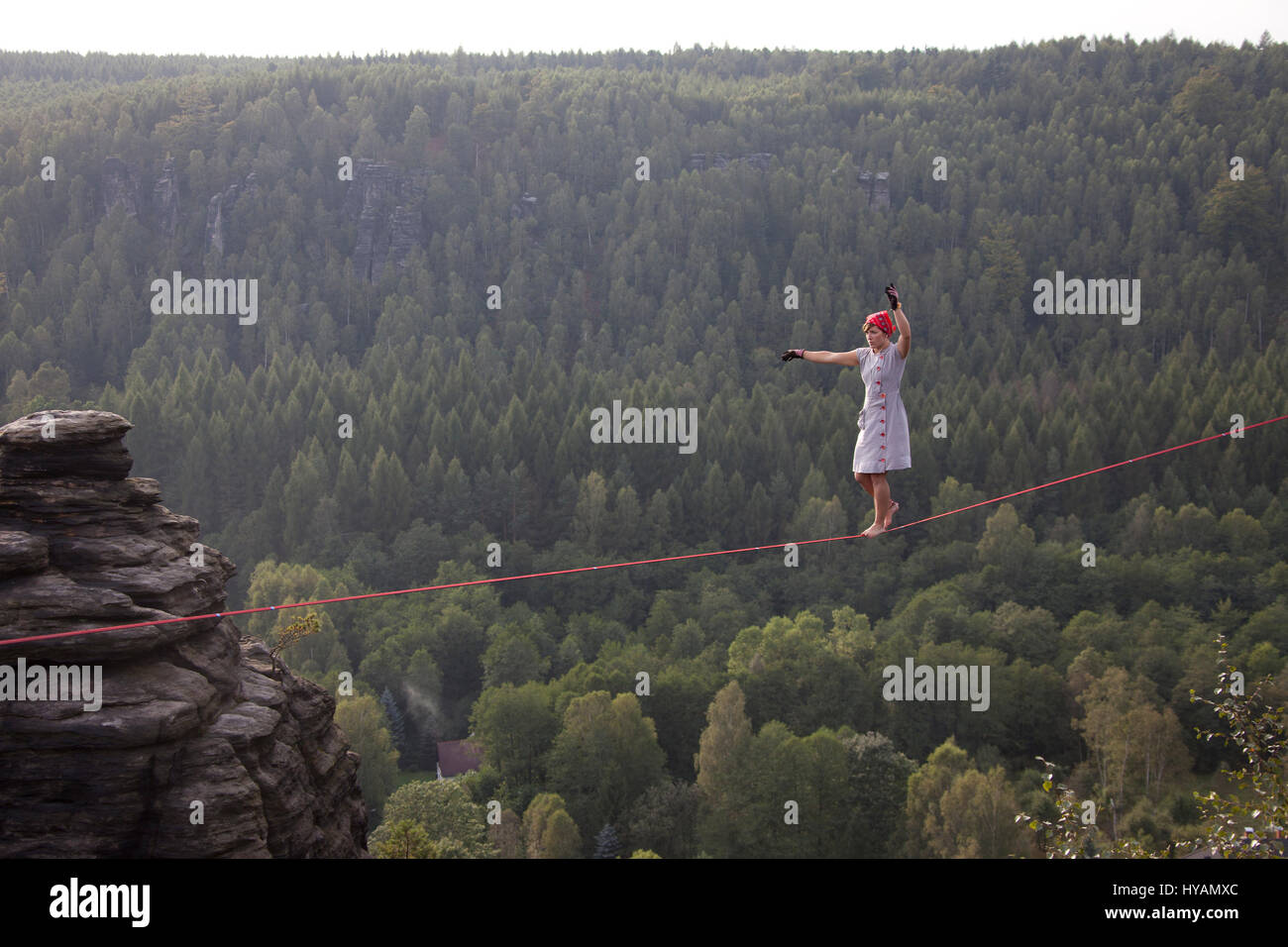OSTROV, REPUBBLICA CECA: una femmina slackliner mostra off in high-filo. Da medicazione in costume alla locazione-filo yoga questo tutti-girl pista mostra il lato leggero al sport estremo che chiamano slacklining. Vestito come un 1940's "Terra Girl' - Fede Dickey (24) può essere visto il completamento di un capello-sollevamento libero-solo a piedi senza una linea di sicurezza, 100-piedi da terra. Altre foto mostrano più sassy slackliners femmina eseguendo sulla high-line in posizioni estreme come pure larking circa in costume. Uno sfrontato angolazione della telecamera quasi illustra un mantello shot. La raccolta di foto è stata presa da phot Foto Stock