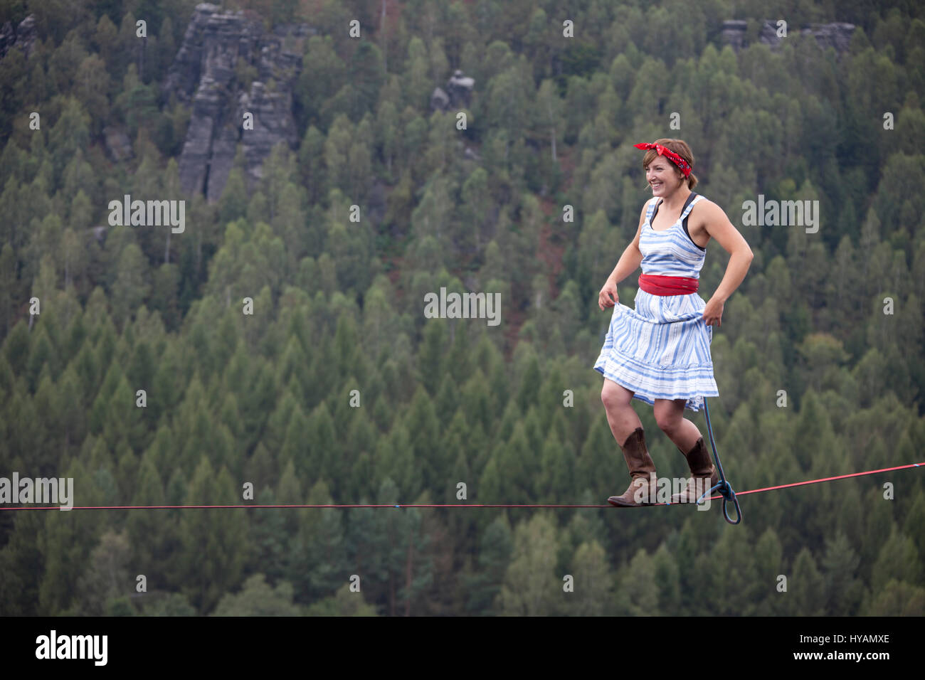 OSTROV, REPUBBLICA CECA: una femmina slackliner mostra off in high-filo. Da medicazione in costume alla locazione-filo yoga questo tutti-girl pista mostra il lato leggero al sport estremo che chiamano slacklining. Vestito come un 1940's "Terra Girl' - Fede Dickey (24) può essere visto il completamento di un capello-sollevamento libero-solo a piedi senza una linea di sicurezza, 100-piedi da terra. Altre foto mostrano più sassy slackliners femmina eseguendo sulla high-line in posizioni estreme come pure larking circa in costume. Uno sfrontato angolazione della telecamera quasi illustra un mantello shot. La raccolta di foto è stata presa da phot Foto Stock