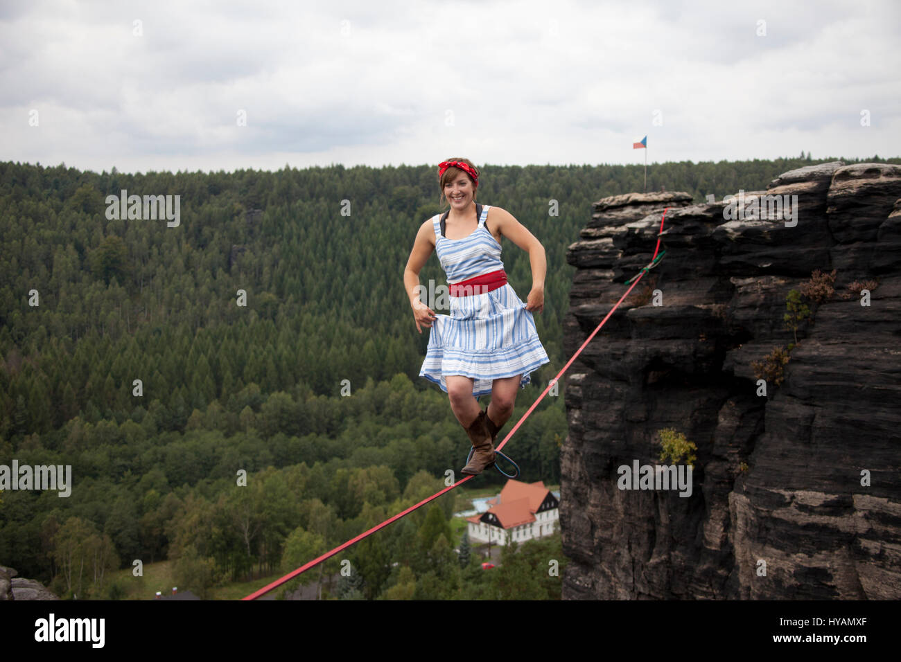 OSTROV, REPUBBLICA CECA: una femmina slackliner mostra off in high-filo. Da medicazione in costume alla locazione-filo yoga questo tutti-girl pista mostra il lato leggero al sport estremo che chiamano slacklining. Vestito come un 1940's "Terra Girl' - Fede Dickey (24) può essere visto il completamento di un capello-sollevamento libero-solo a piedi senza una linea di sicurezza, 100-piedi da terra. Altre foto mostrano più sassy slackliners femmina eseguendo sulla high-line in posizioni estreme come pure larking circa in costume. Uno sfrontato angolazione della telecamera quasi illustra un mantello shot. La raccolta di foto è stata presa da phot Foto Stock
