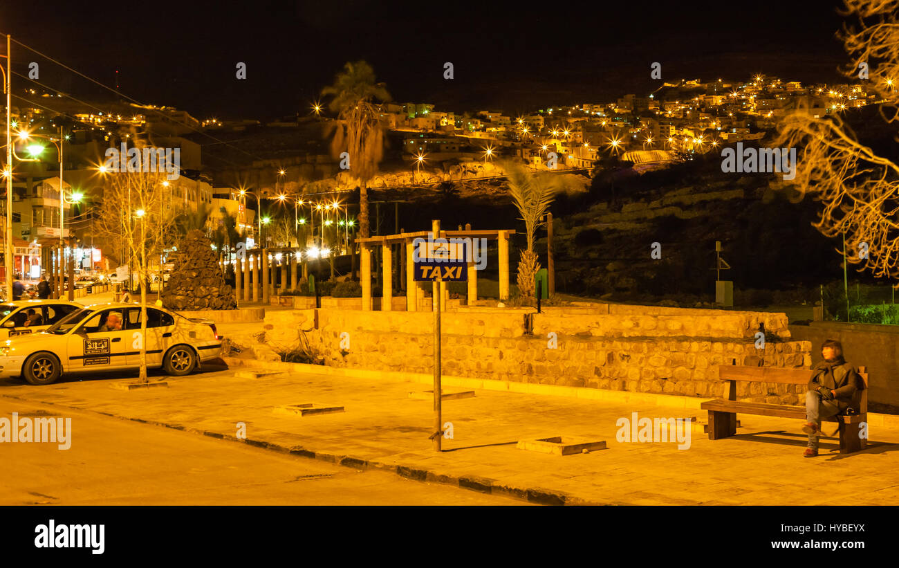 PETRA, GIORDANIA - Febbraio 21, 2012: taxi parcheggio vicino alla città di Petra e la vista della città di Wadi Musa nella notte. Wadi Musa è il centro amministrativo e th Foto Stock