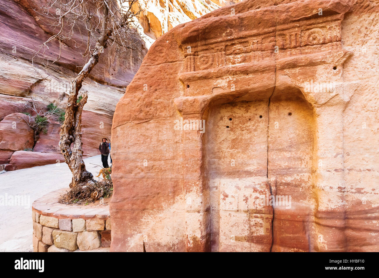 PETRA, GIORDANIA - Febbraio 21, 2012: turisti nei pressi di nicchie di pietra in Al Siq passano all'antica città di Petra in inverno. Rock-cut town Petra fu stabilito abou Foto Stock