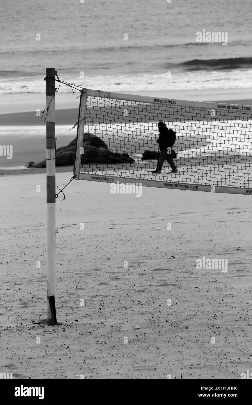 Qualcuno camminare da solo lungo la sabbia sulla riva della spiaggia di Matosinhos, Porto, Portogallo. Foto Stock