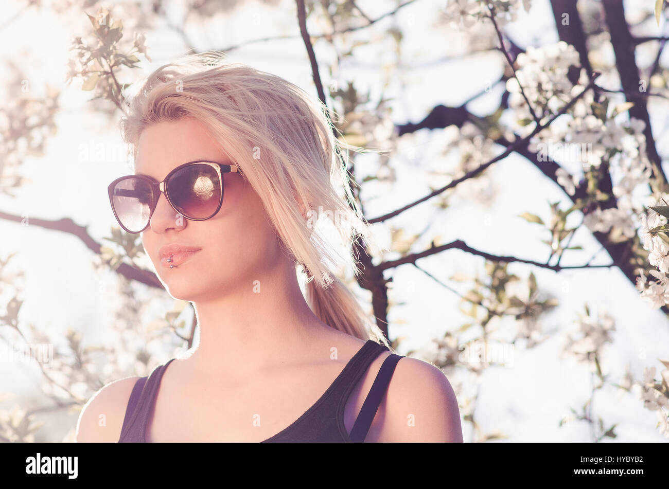 Giovane donna con occhiali da sole di primavera in verticale il sole Foto  stock - Alamy