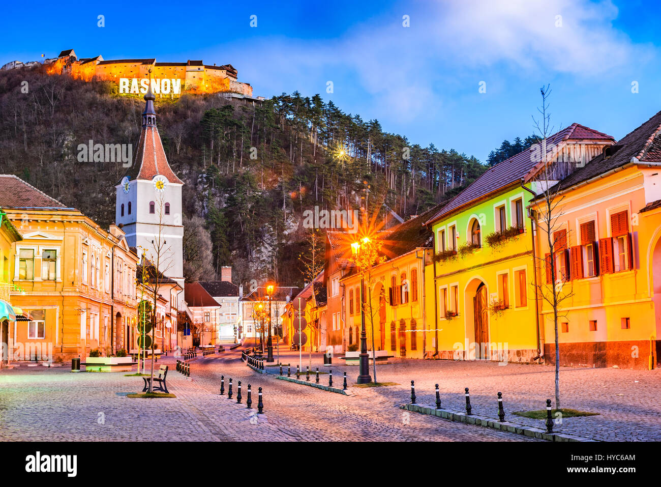 Rasnov, Romania. Crepuscolo serale con la medievale città sassoni di Transilvania e hilltop rovine della fortezza. Foto Stock