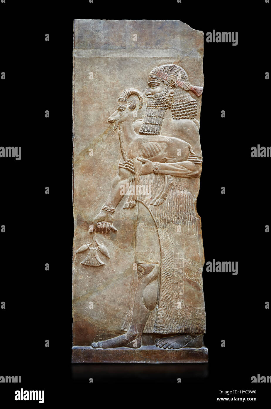 Pietra scolpita in rilievo pannello di un uomo con un Ibex e semi di papavero in cialde. Facciata nord Inv AO 19872 da Dur Sharrukin il palazzo del re assiro Sarg Foto Stock