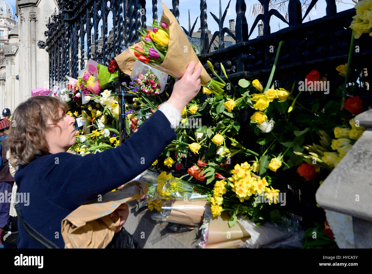 Omaggi floreali essendo collocati sulle recinzioni presso la sede del parlamento di Londra, in onore di PC Keith Palmer e altri uccisi dall'azione terroristica Foto Stock