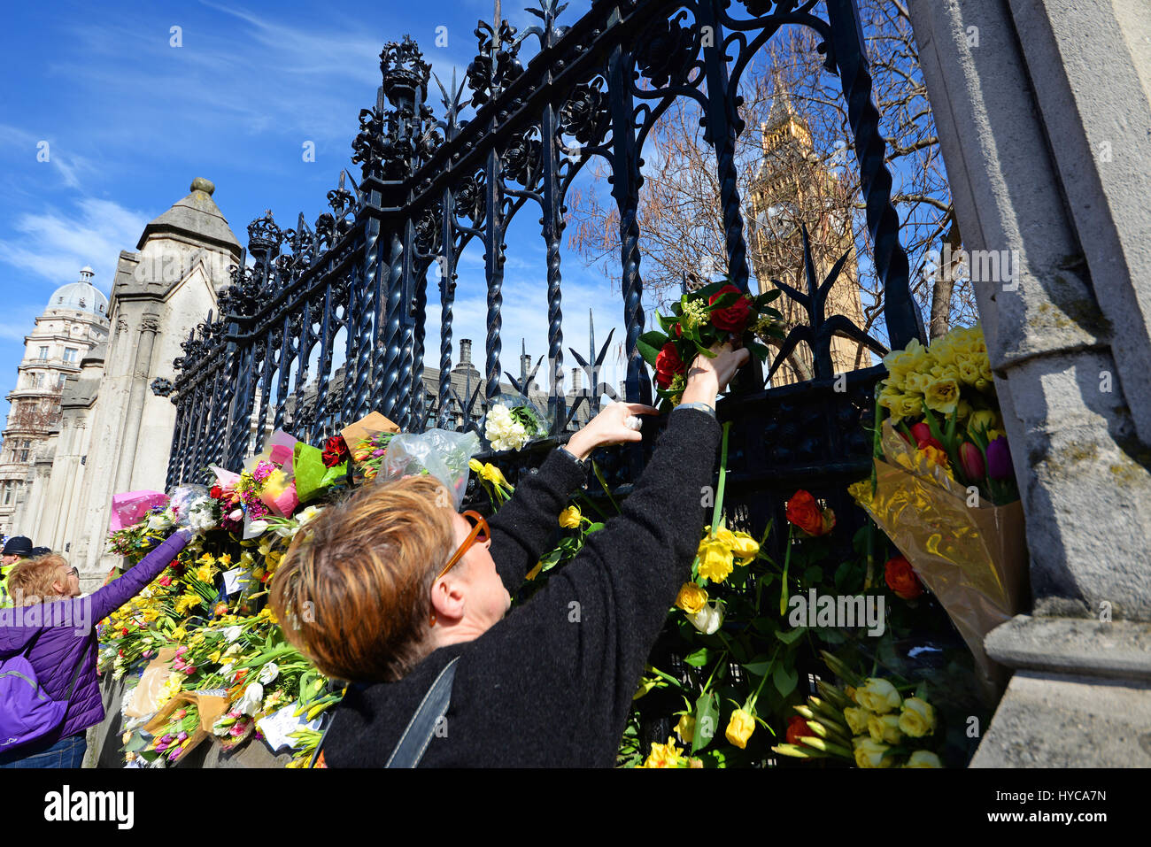 Omaggi floreali essendo collocati sulle recinzioni presso la sede del parlamento di Londra, in onore di PC Keith Palmer e altri uccisi dall'azione terroristica Foto Stock
