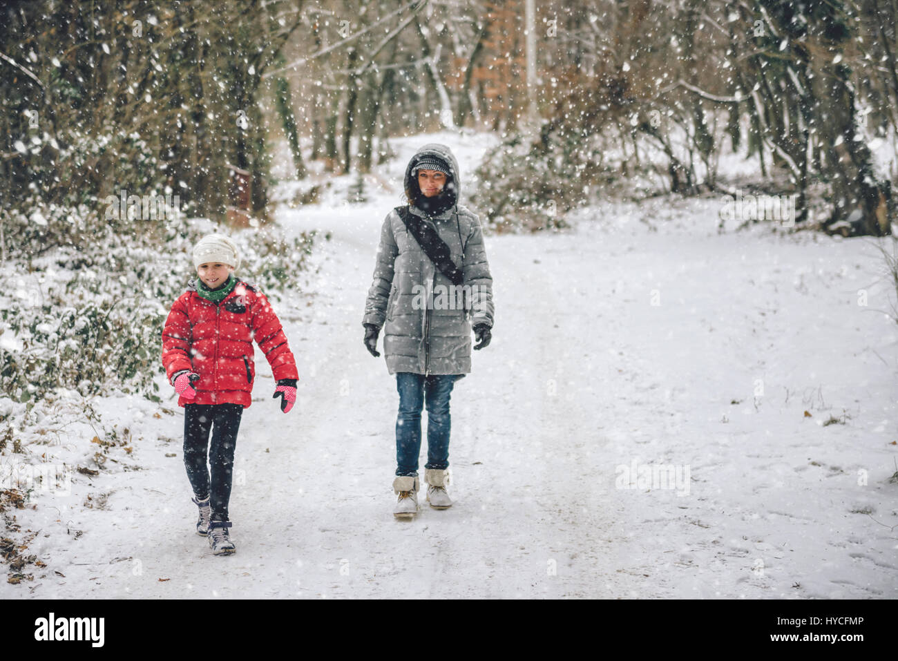 Madre e figlia escursionismo in bianco inverno forest Foto Stock