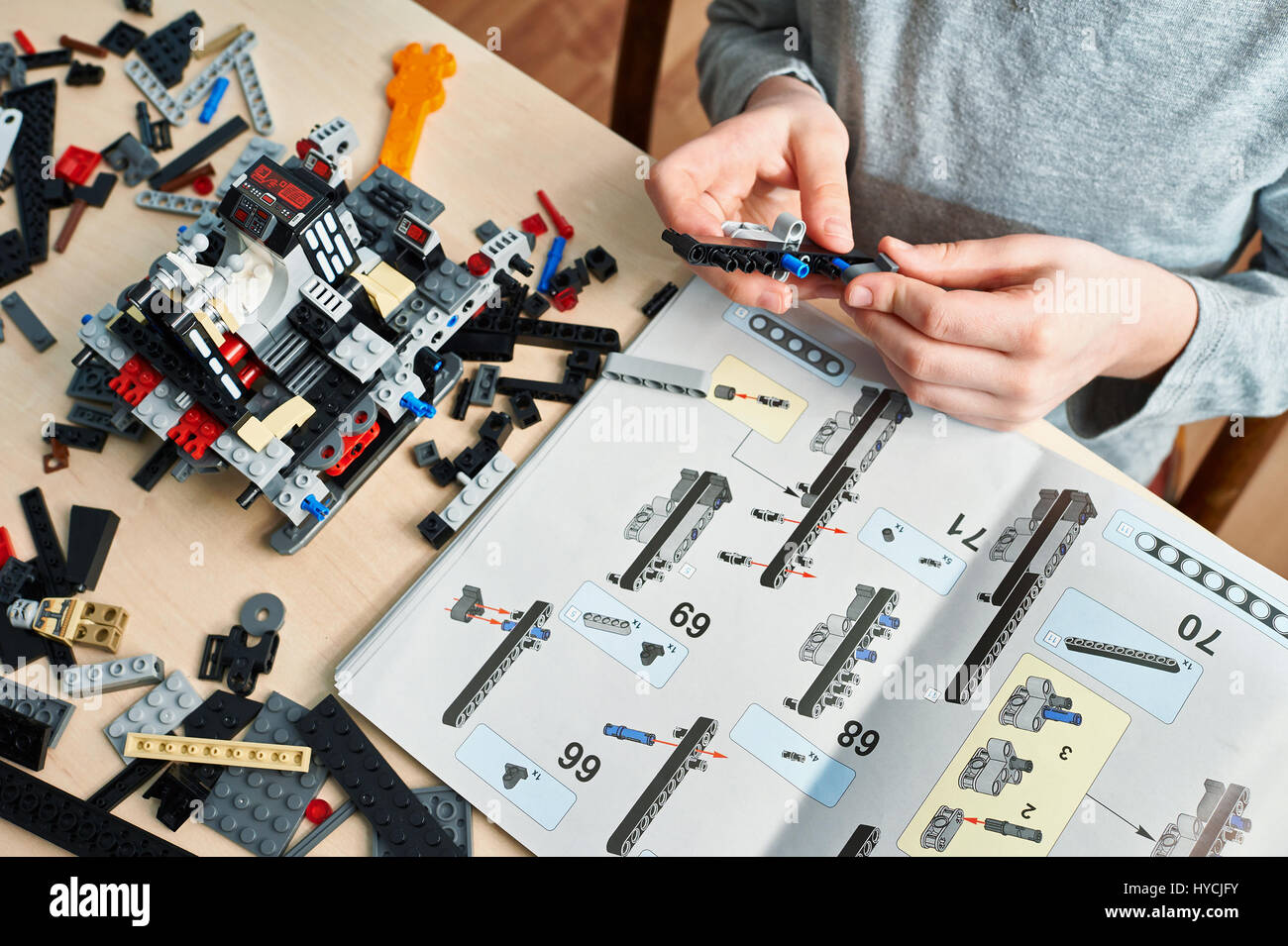 Ragazzo raccoglie i bambini in plastica giocattoli da costruzione Foto Stock