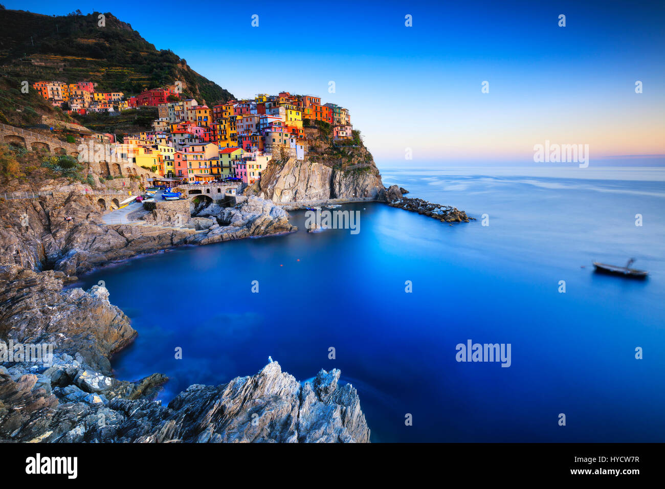 Manarola village sulla scogliera di rocce e mare al tramonto., Seascape in cinque terre, il Parco Nazionale delle Cinque Terre Liguria Italia Europa. Esposizione lunga Foto Stock
