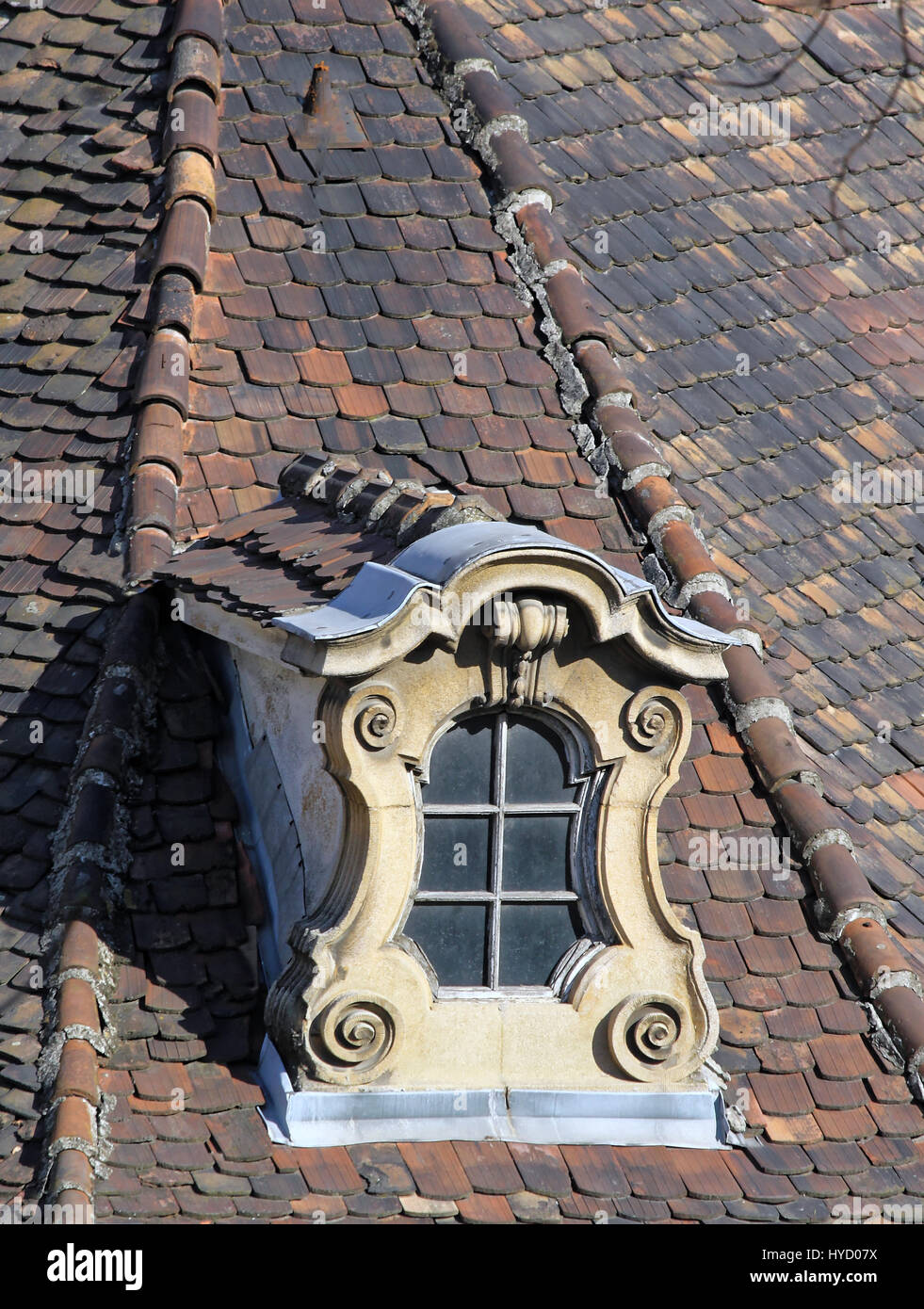 Weathered vecchio ornano finestre dormer e tegole del tetto. Foto Stock