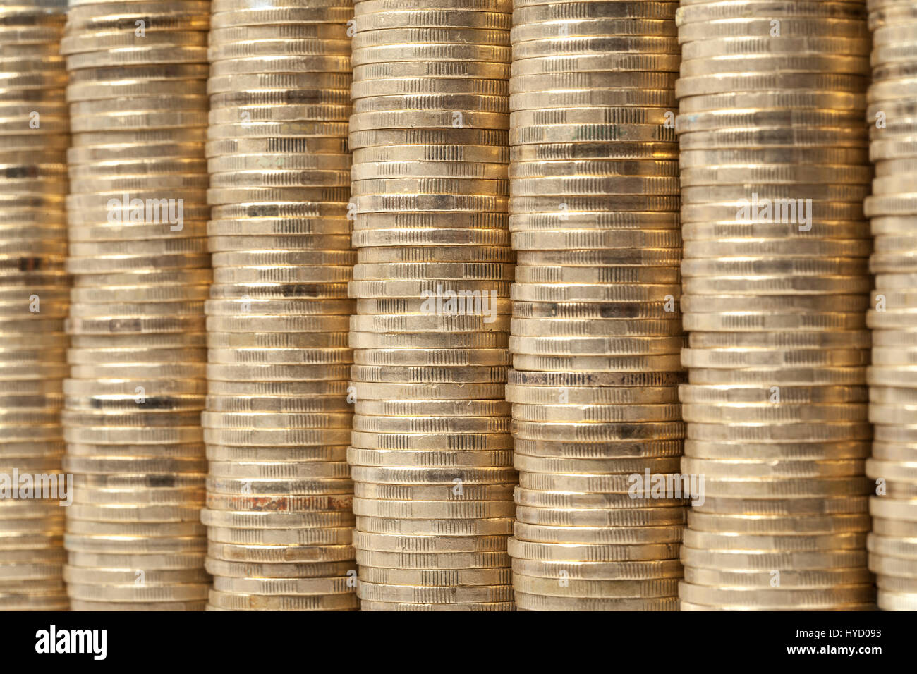 Molti e alta monete pile disposte una di fianco all'altra come sfondo. Foto Stock