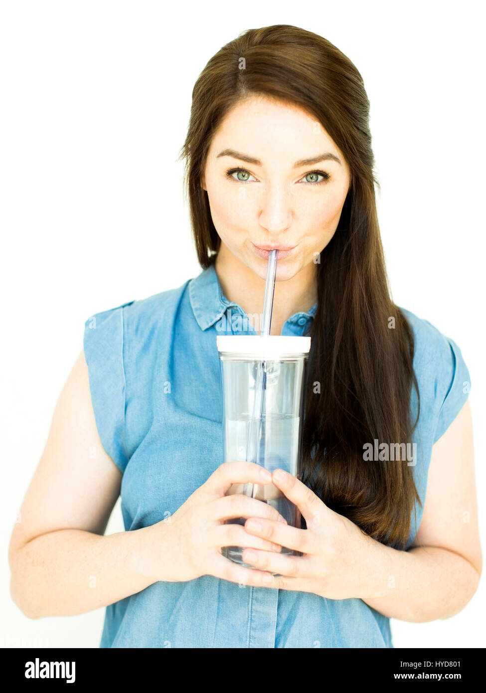 Donna che indossa acqua potabile dalla parte superiore blu del bicchiere Foto Stock