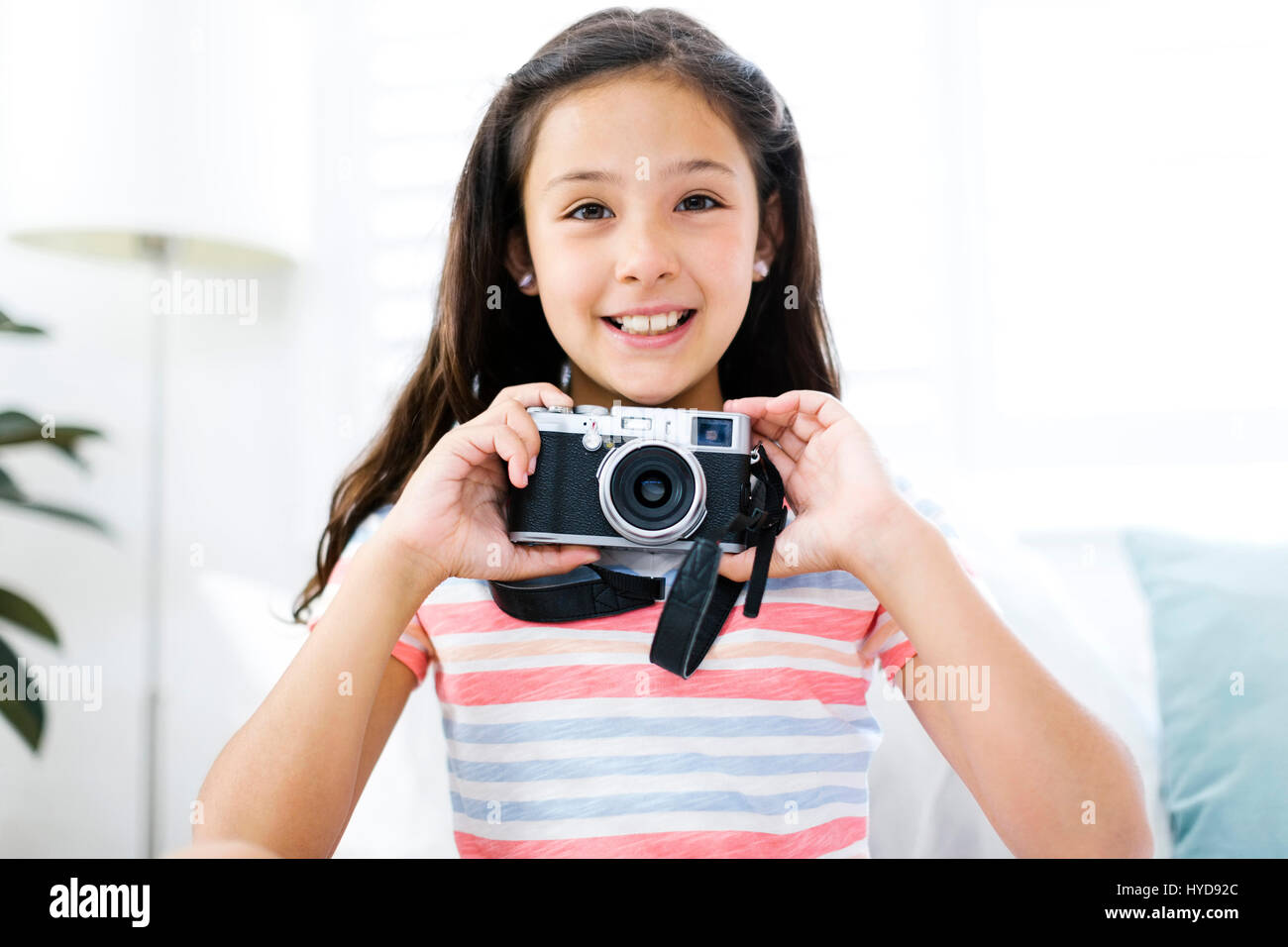 Ragazza sorridente (10-11) con macchina fotografica Foto Stock