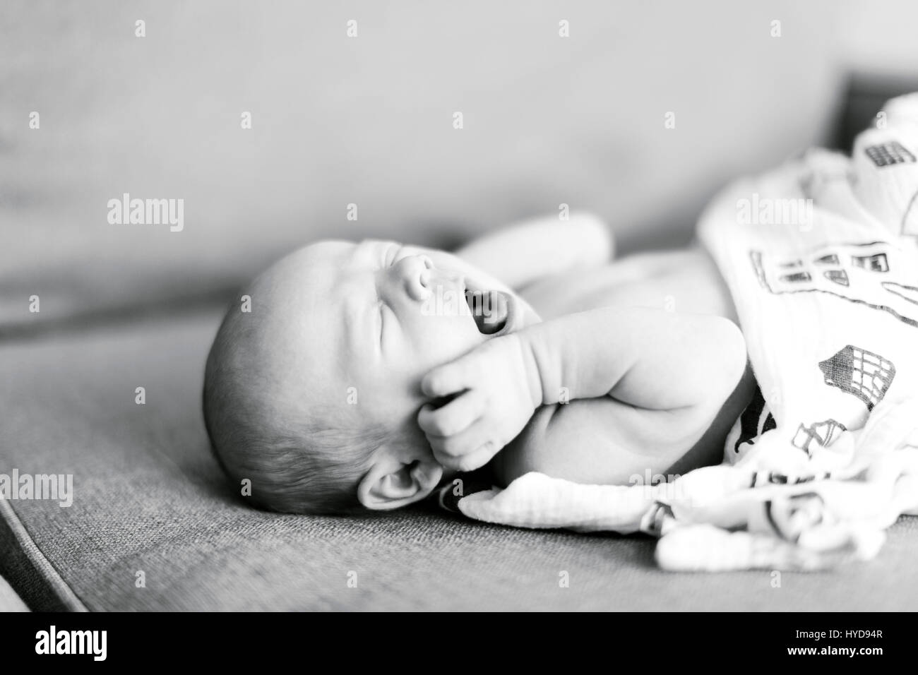 Bambino ragazzo (0-1 mesi) sdraiato sulla schiena e sbadigliato Foto Stock