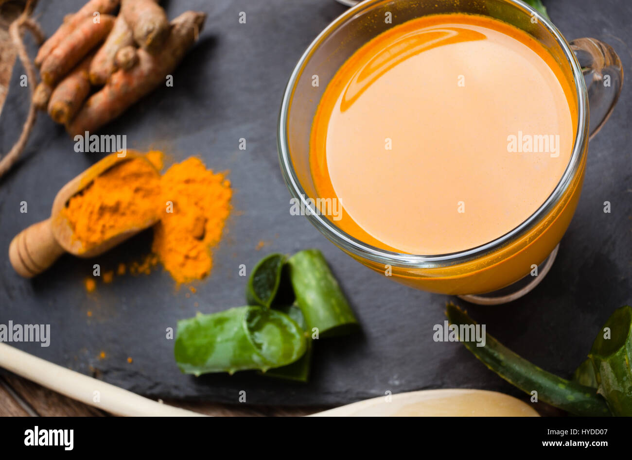 Bere aloe vera e la curcuma. Vista superiore delle coppe di vetro su un vassoio di ardesia Foto Stock