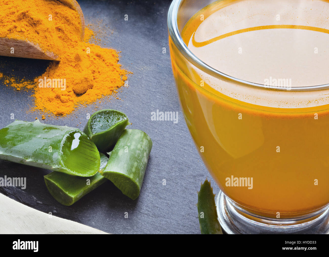 Bere aloe vera e la curcuma. Le coppe di vetro su un vassoio di ardesia Foto Stock