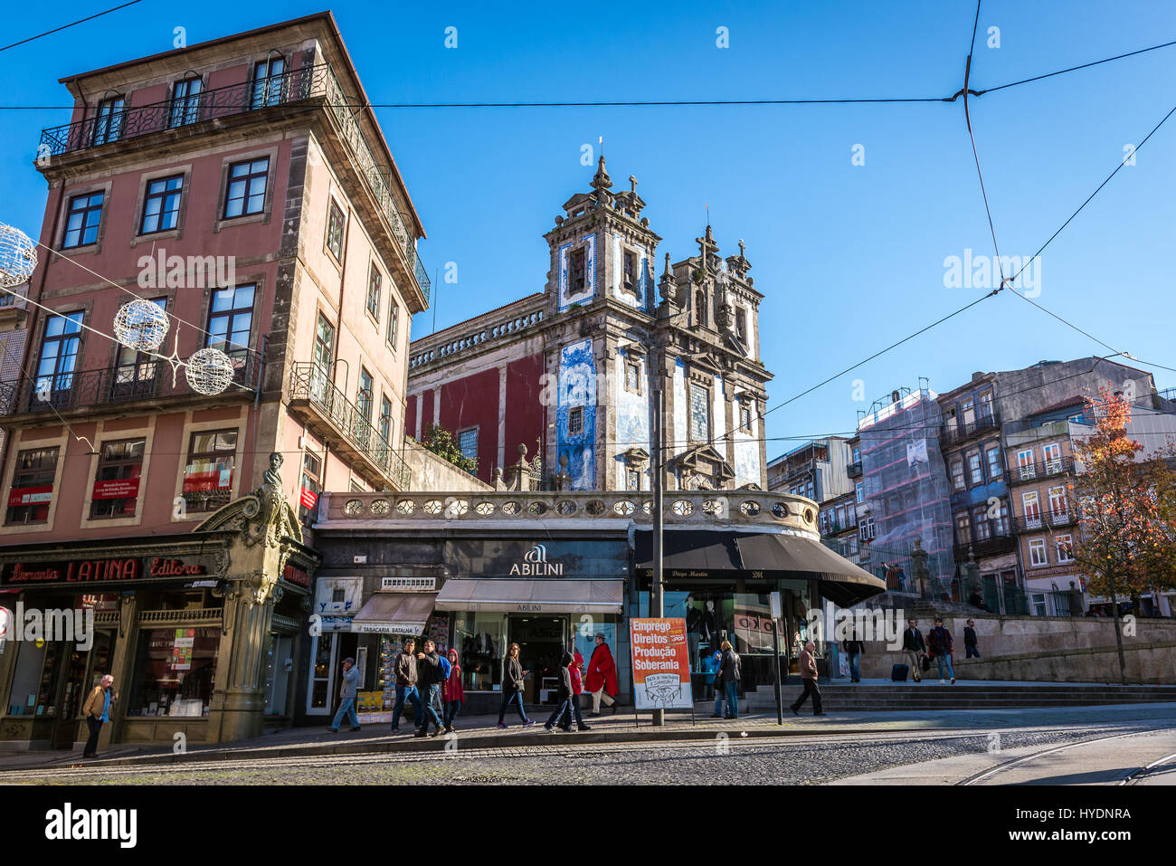 Negozi sulla piazza di Batalha in Santo Ildefonso parrocchia civile della città di Porto, Portogallo. Vista con chiesa di San Ildefonso di Toledo Foto Stock
