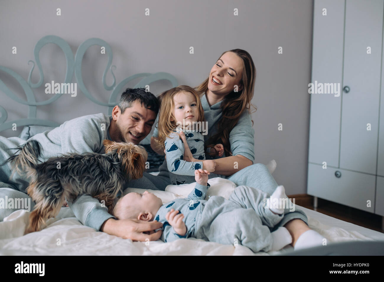 Madre, padre e figlia e baby sul letto Foto Stock