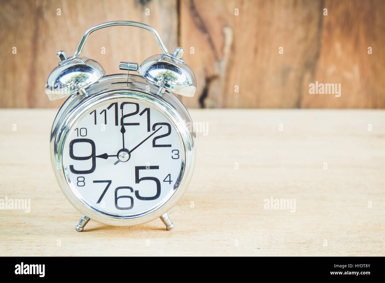 Mostra orologio 9 am o pm su uno sfondo di legno con copia spazio. Foto Stock