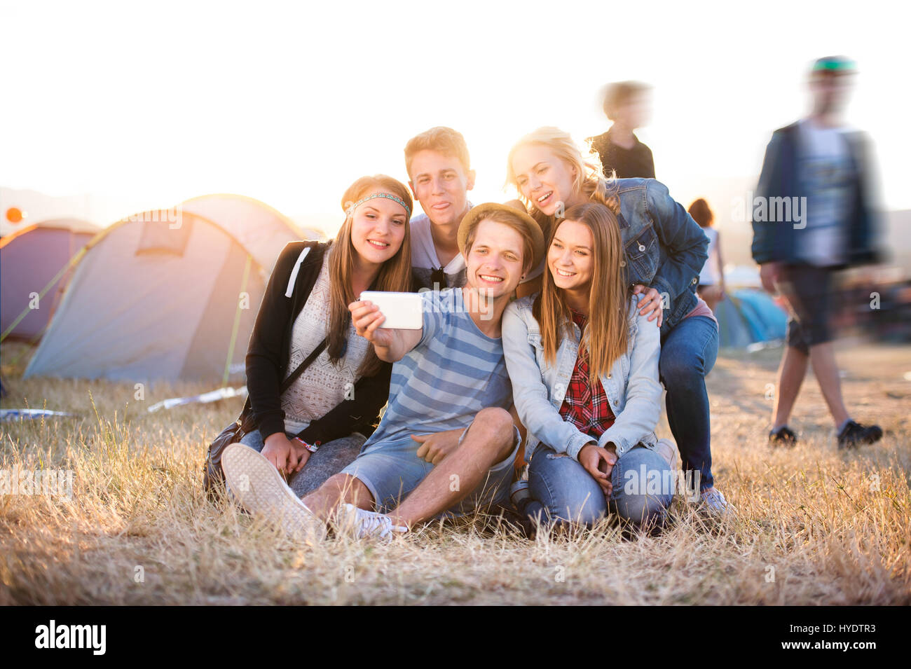 Gli adolescenti presso i festival estivi di musica, tenendo selfie con smartphon Foto Stock