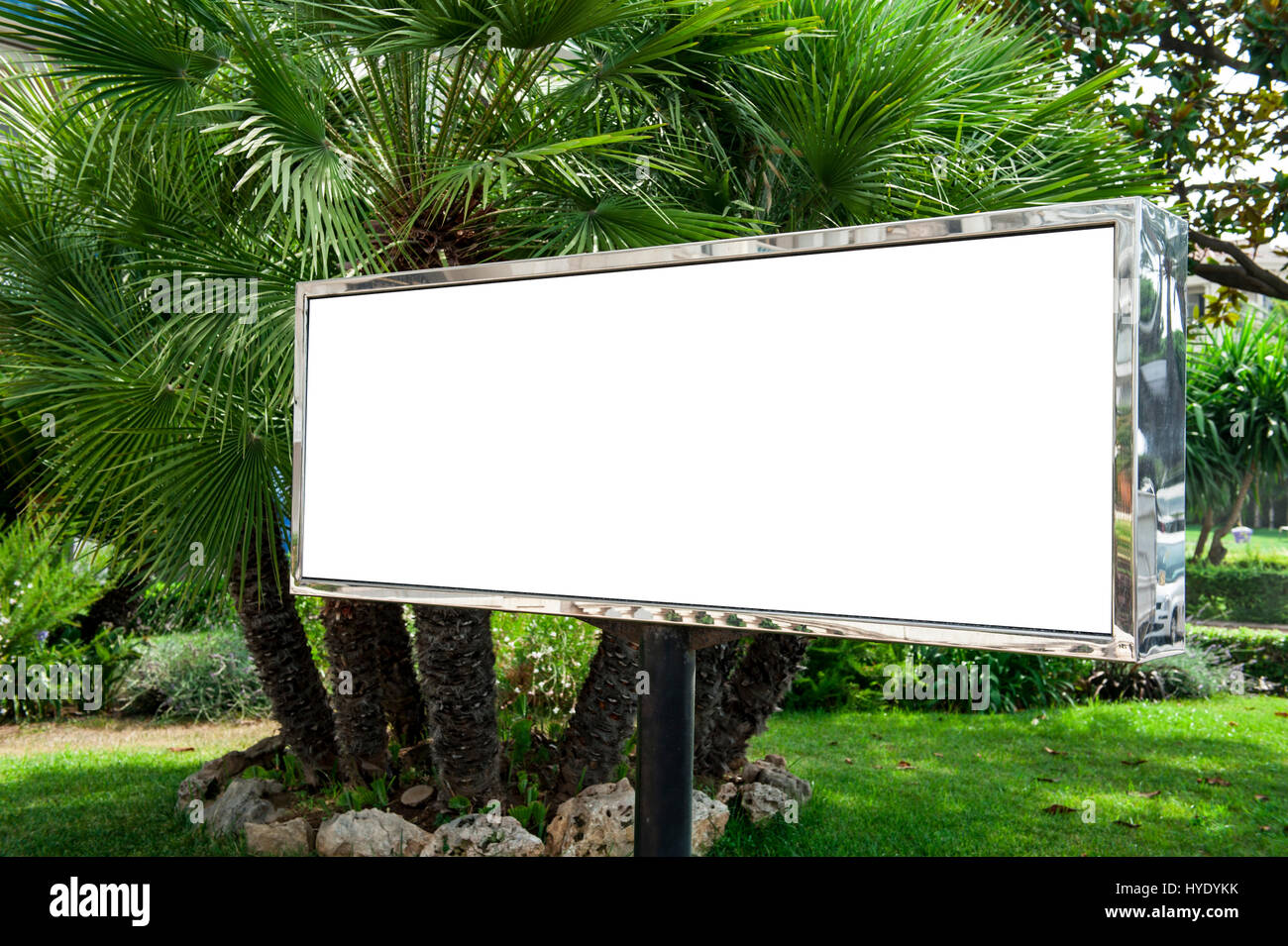 Tabellone bianco in un giardino con palme Foto Stock