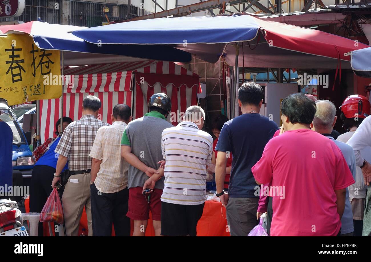 KAOHSIUNG, Taiwan -- Aprile 5, 2015: gli acquirenti la linea fino a comprare involtini primavera, thin wrapper di pasta con ripieno di verdure e beancurd. Questo alimento è tradit Foto Stock