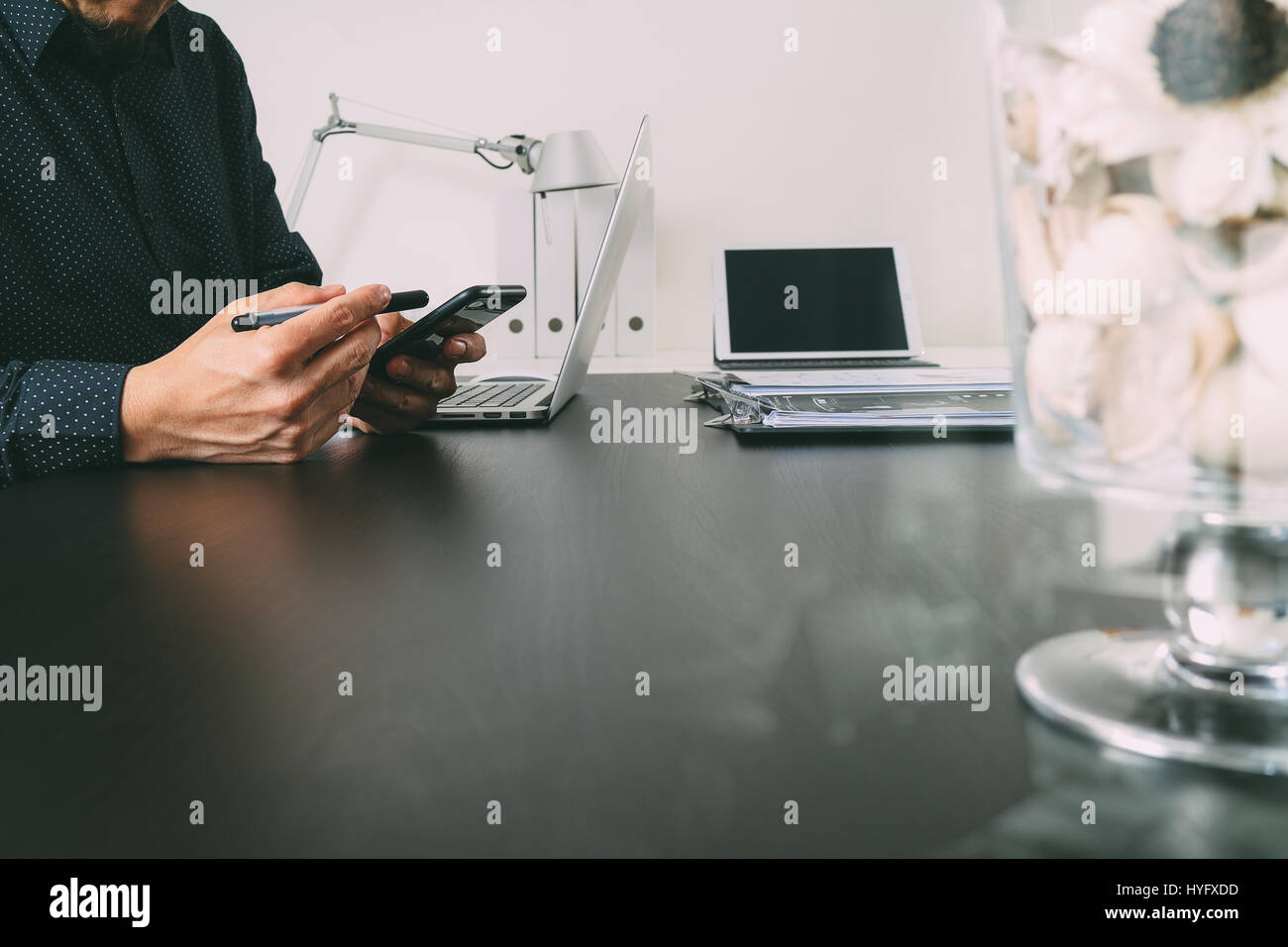 Imprenditore o il progettista utilizzando smart phone con latop e tavoletta digitale computer in ufficio moderno Foto Stock