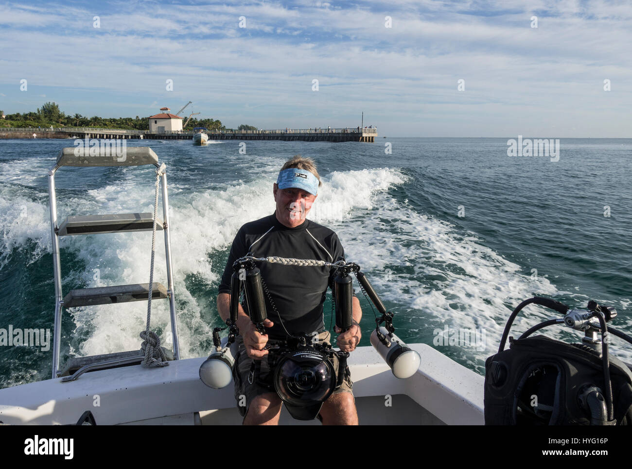 Colpo di Testa del fotografo Alan C. Egans. Giove in Florida, TIGER BEACH BAHAMAS: Diver alimentare pesce di Hammerhead. Tenendo un piede di sedici-lungo tiger shark nelle sue mani un coraggioso British subacqueo può essere visto posizionando il predatore selvatico in un sogno come la trance di novanta piedi sott'acqua. Con solo un paio di pollici tra di loro, il subacqueo tratti e allevia lo squalo in una procedura chiamata "immobilità tonica", spesso usato per calmare gli squali al fine di rimuovere i ganci dalle loro bocche o gola. Altre foto evidenziare gli affilati denti all'interno di entrambi i tigre e gli squali limone' bocche mentre la mano del subacqueo feed Foto Stock