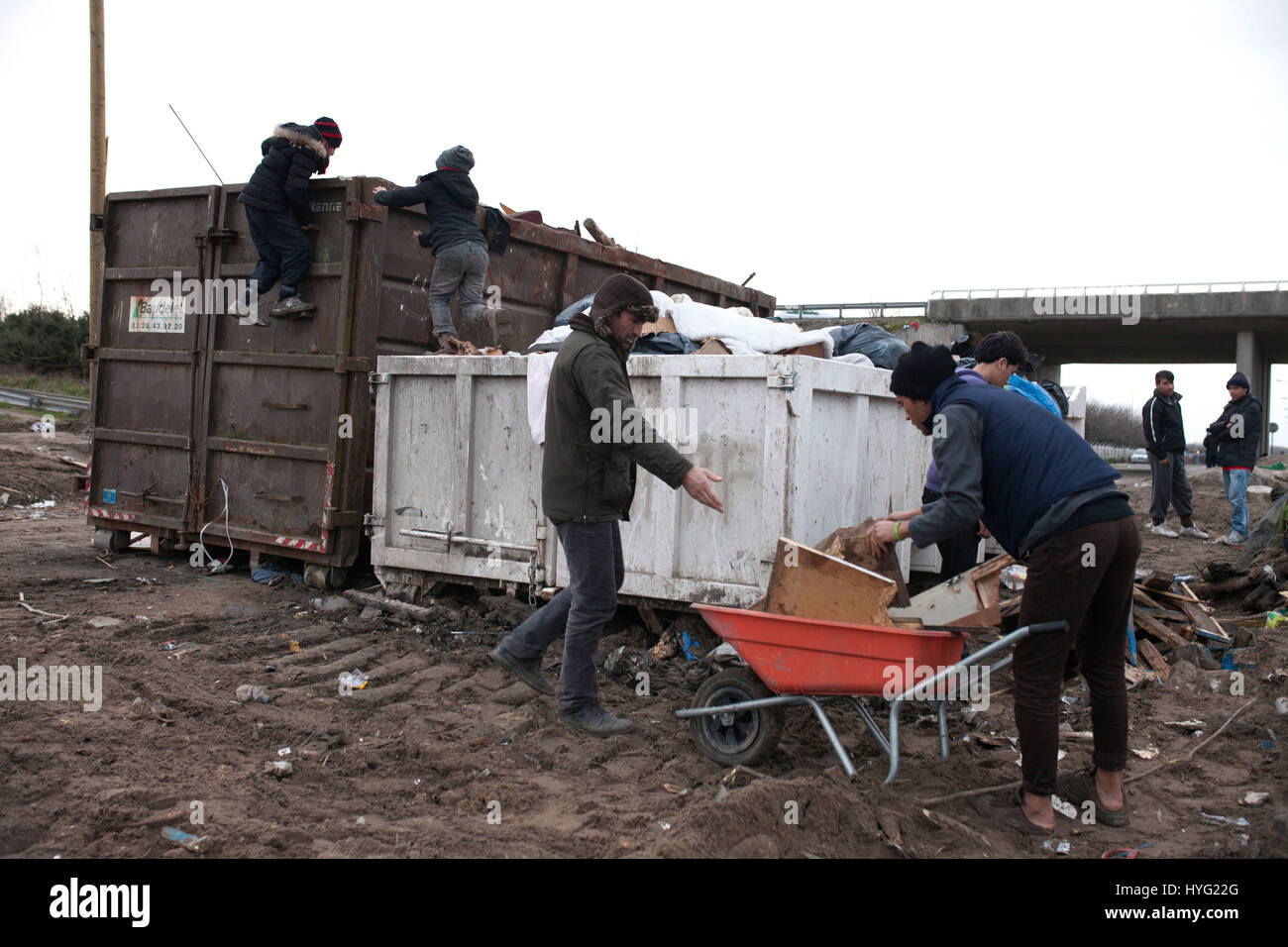 Gennaio,2016. I rifugiati pick legna dopo la demolizione di un area dove i rifugiati avevano costruito rifugi in campo profughi nelle dune di Calais, Francia.Il campo di rifugiati a Calais è nelle fasi finali di essere cancellato dalla polizia francese. Le immagini mostrano come bulldozer protetti da agenti di sicurezza hanno lasciato quasi una traccia di ciò che una volta erano strettamente impaccate rifugi. Il controverso camp, che è stata la casa di circa 6.000 migranti principalmente dalla Siria e dal Nord Africa, viene rimosso in maniera costante da parte delle autorità. Foto Stock