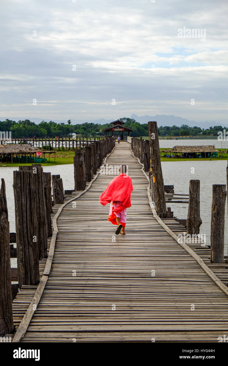 Amarapura, Myanmar - 28 Giugno, 2015: giovane monaco passeggiate su legno U Bein bridge in Amarapura, Myanmar Foto Stock