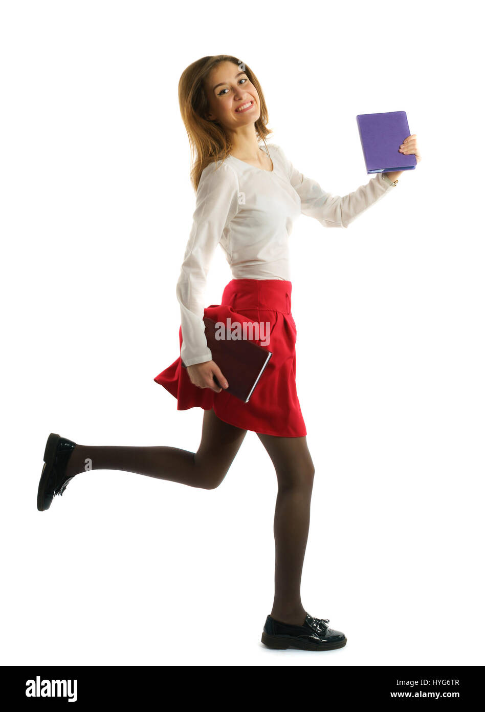 A piena lunghezza Ritratto di una ragazza dello studente in esecuzione con i notebook isolati su sfondo bianco Foto Stock
