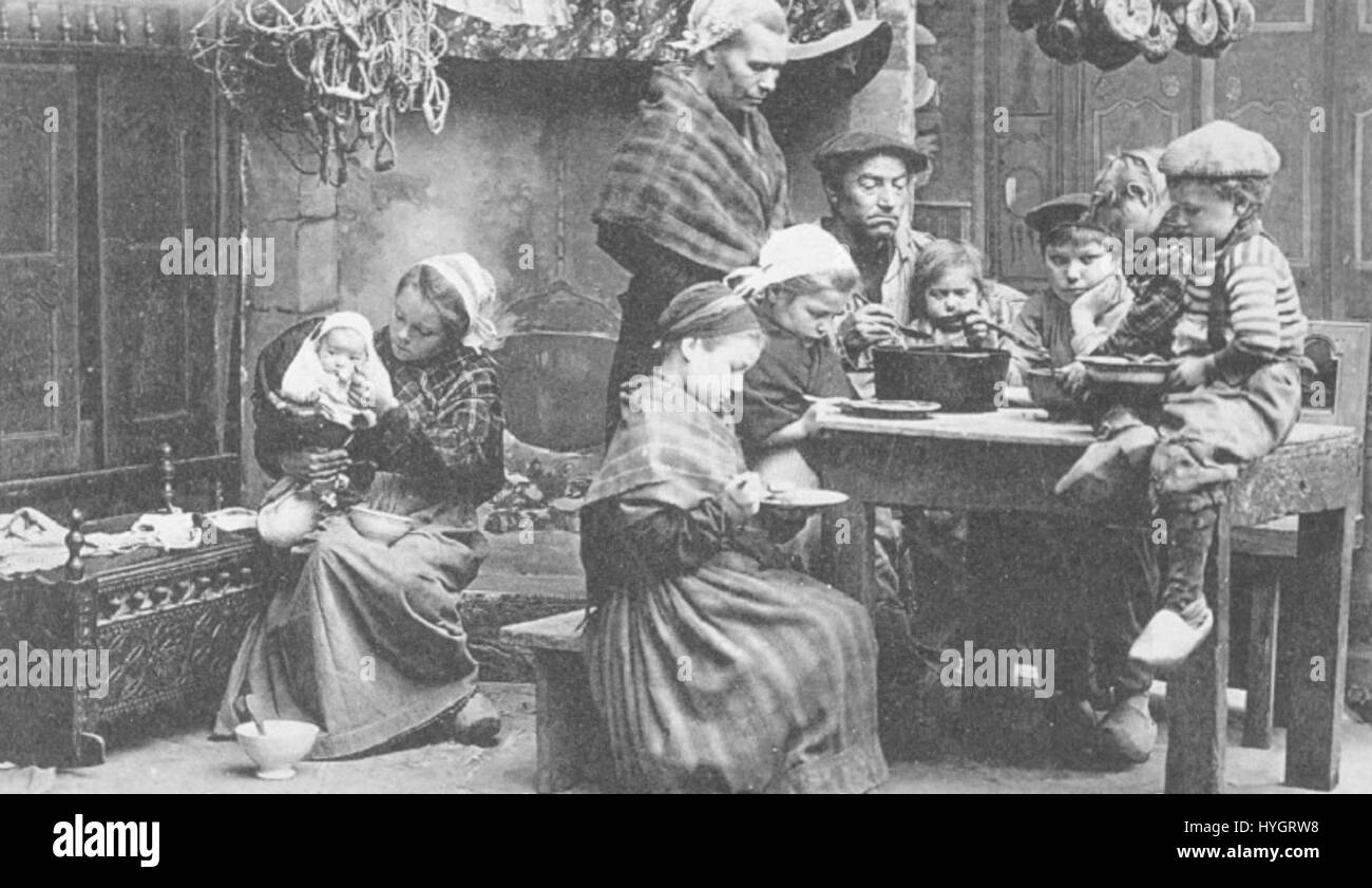 "Repas de famille Concarneau" raffigura un pasto di famiglia, probabilmente un momento di connessione sociale e familiare. La scena offre uno sguardo sulla vita quotidiana di una famiglia, riflettendo un'enfasi culturale sui pasti condivisi e sulle riunioni della comunità a Concarneau, in Francia. Foto Stock