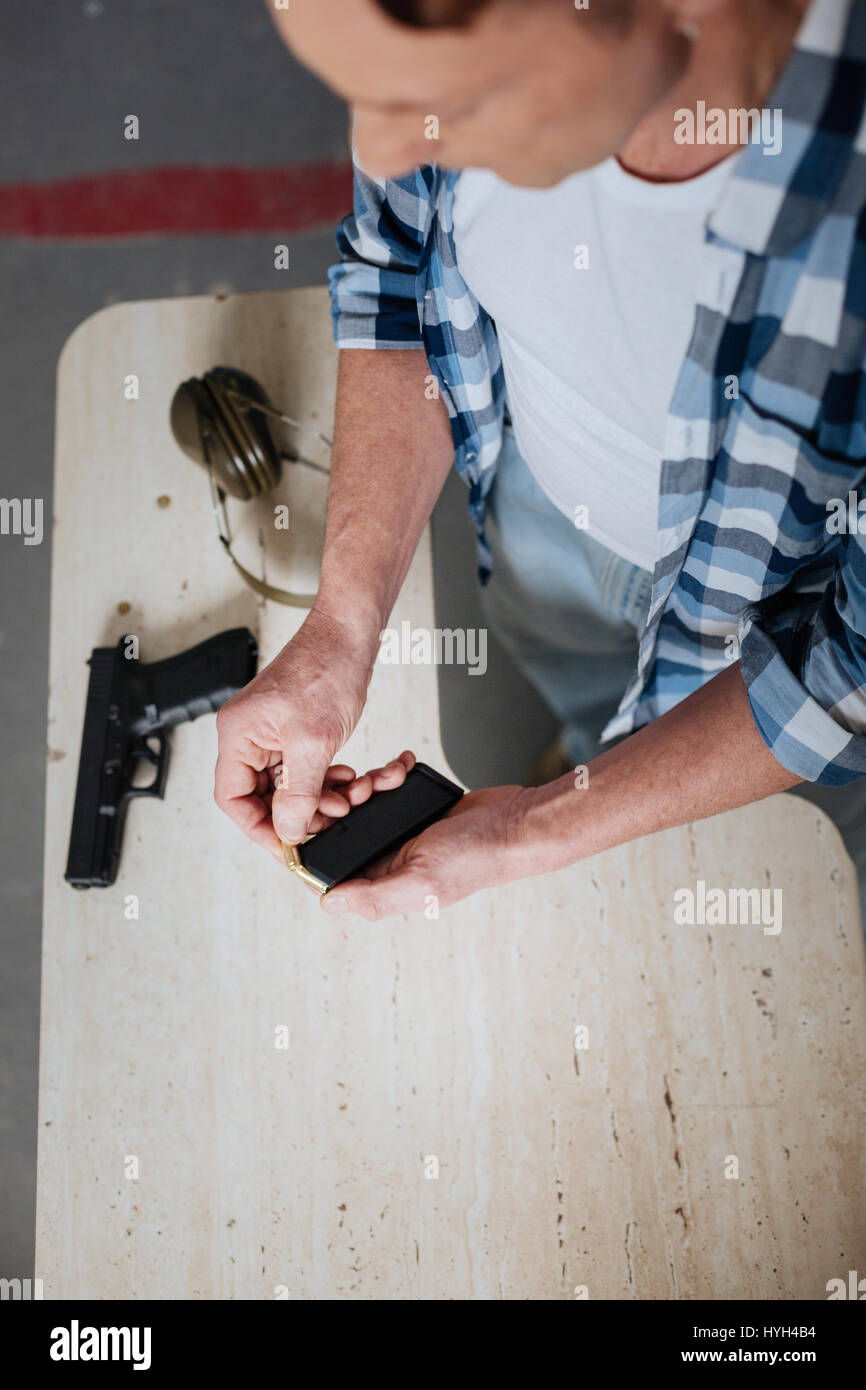 Nice professional marksman ricaricando il fermo della cartuccia Foto Stock