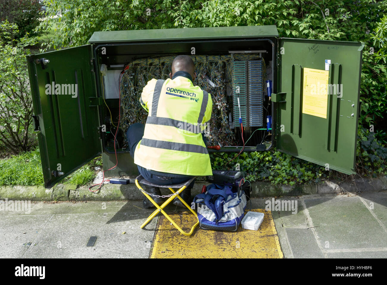 BT Openreach ingegnere, lavorando su una strada con scatola di giunzione, Londra, Regno Unito. Foto Stock