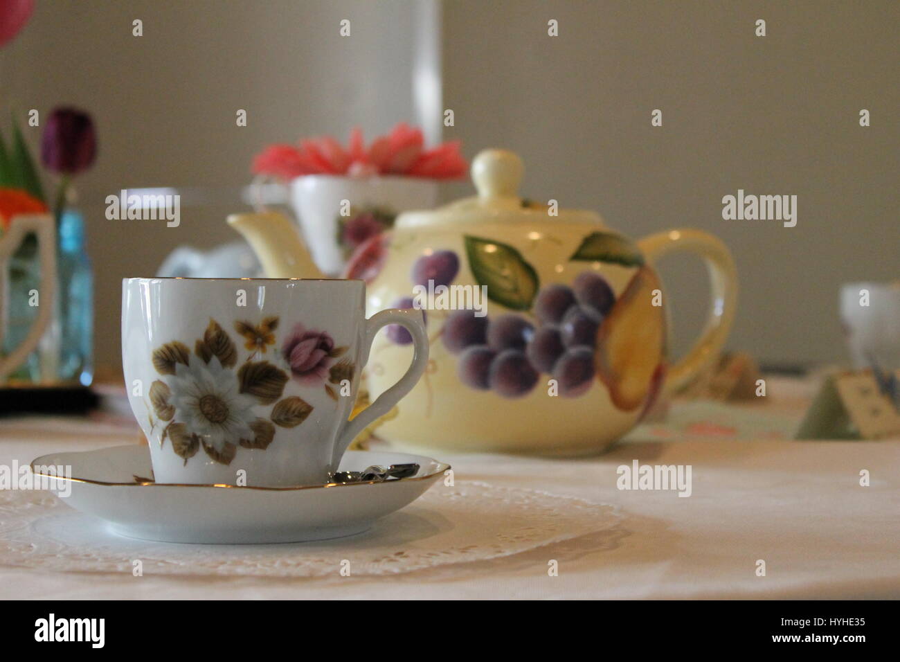 Una focalizzazione di tazza da tè su una tabella con una offuscata tè pentola in background Foto Stock
