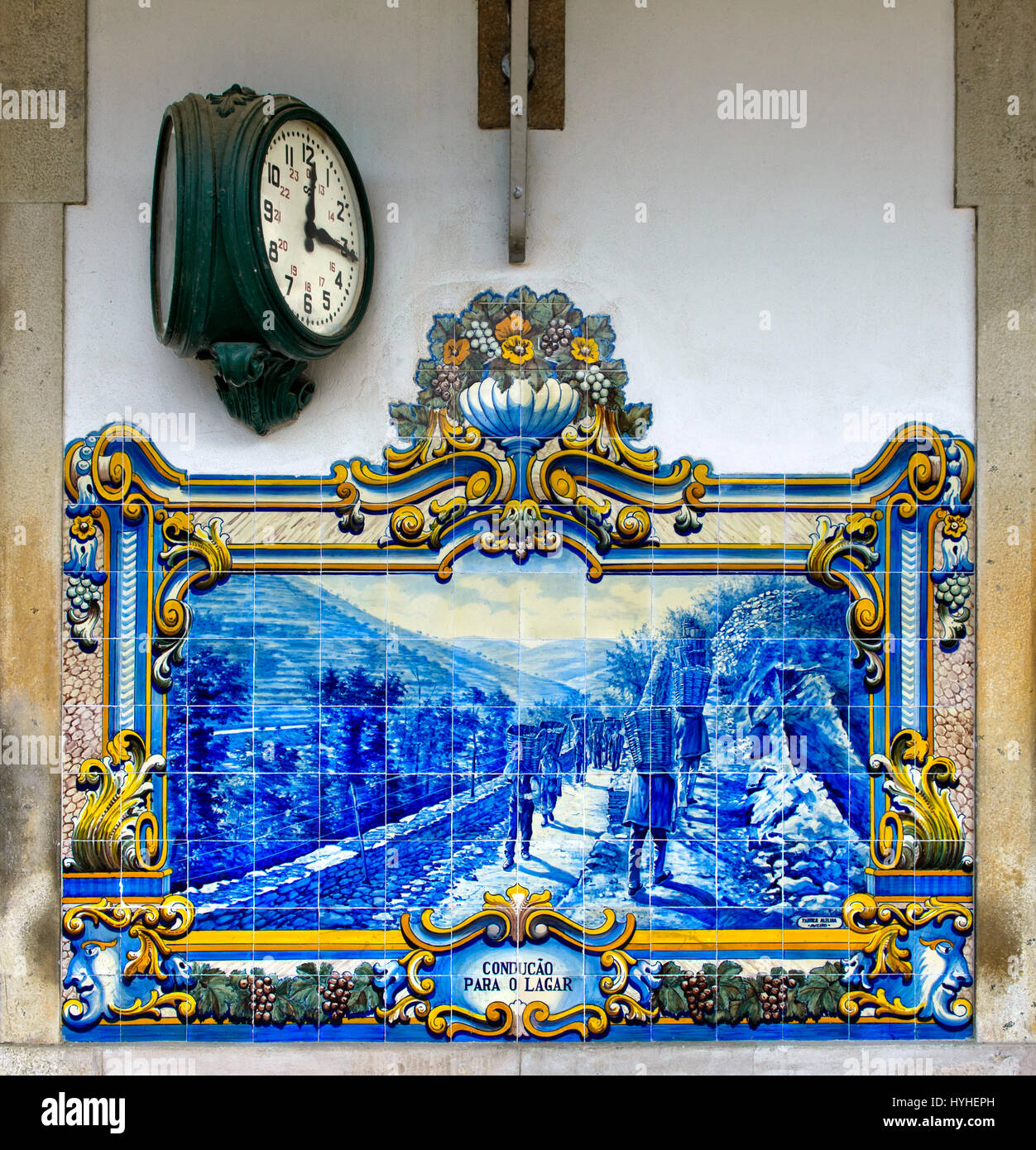 Orologio di stazione e dipinte a mano e le piastrelle di ceramica, azulejos, a Pinhao stazione ferroviaria raffiguranti scene della vendemmia in la regione del Douro, Pinhao, Foto Stock