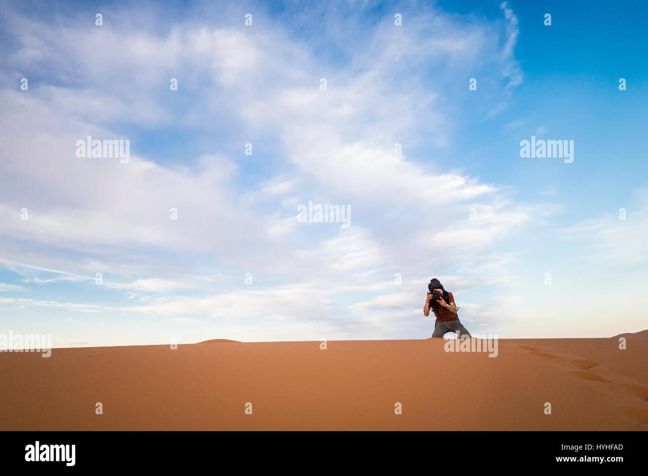 Un uomo è scattare foto sulle dune nel deserto del Sahara al tramonto - Merzouga - Marocco Foto Stock