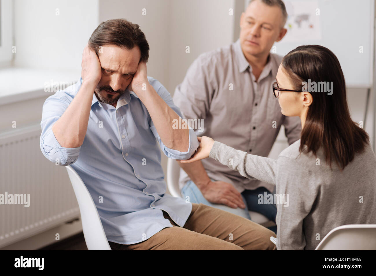 Caparbio uomo di mettere le mani sui suoi orecchi Foto Stock